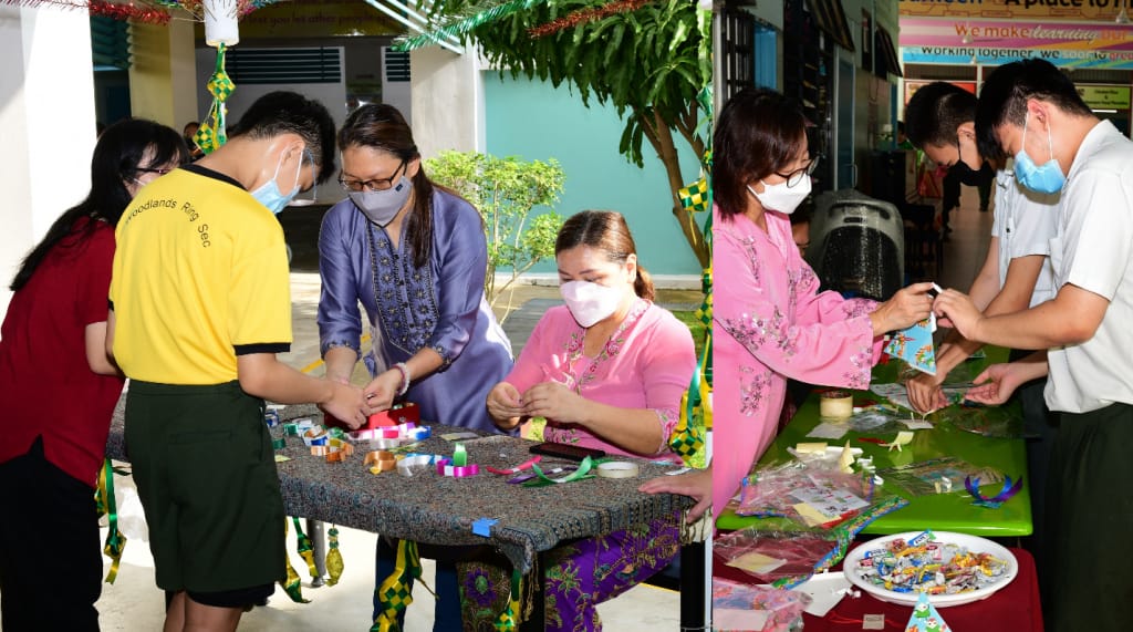 Several masked people gather around tables doing a craft activity outdoors, with colorful decorations hanging nearby.